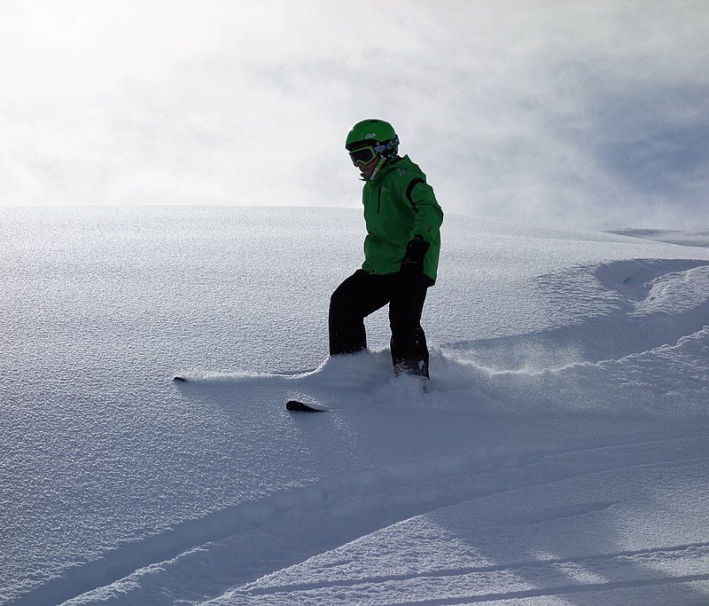 Skier skiing through fresh powder without poles.