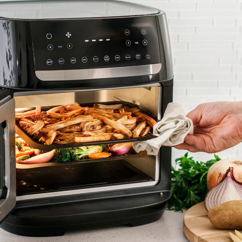 The Bella Pro Series air fryer oven with fries and vegetables being cooked.