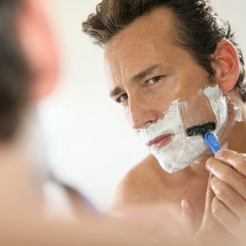 Man shaving with razor blade