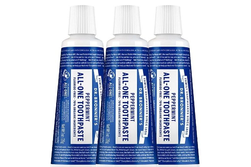 Three tubes of Dr. Bronner’s All-One Toothpaste Peppermint on plain background.