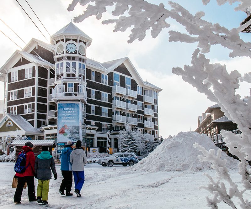 A group of people walking in front of Snowshoe resort in West Virginia.
