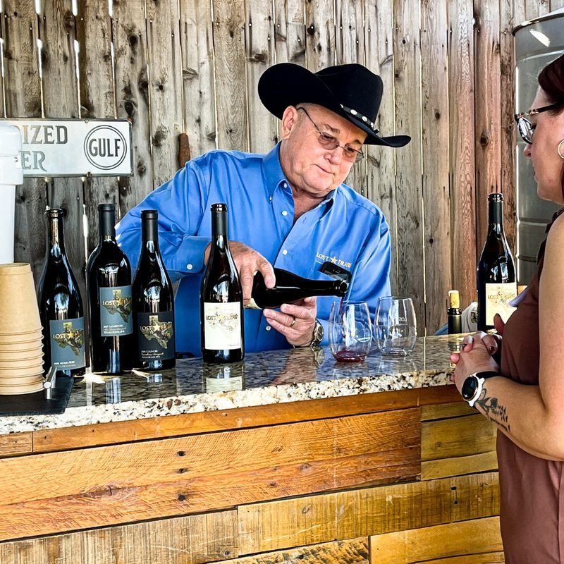 A man pouring wine for a customer at a Lost Draw Cellars tasting.