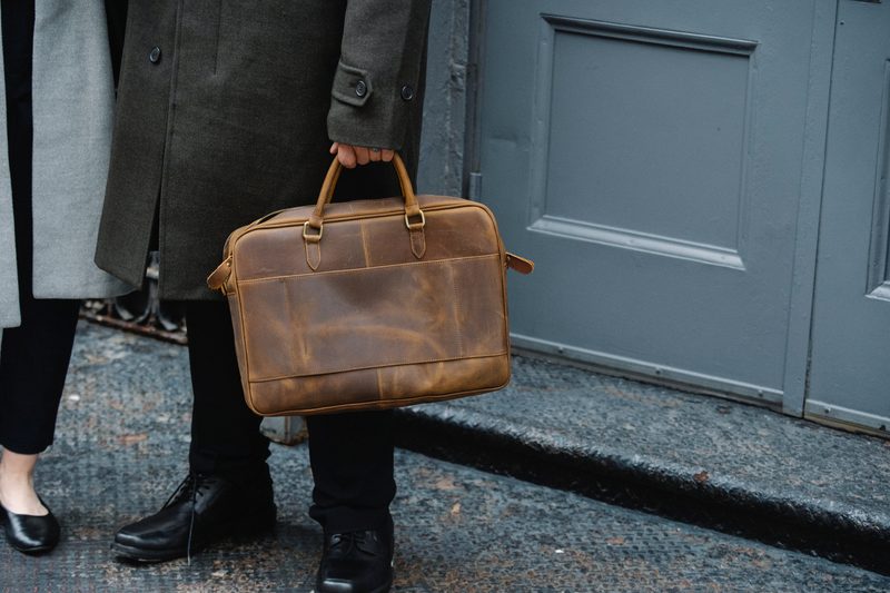 man carrying leather briefcase