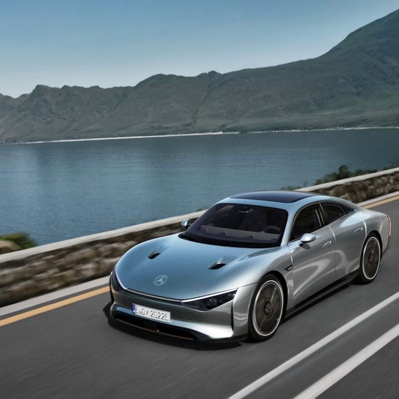 Mercedes-Benz Eqxx Concept driving on a road with a lake in the background.