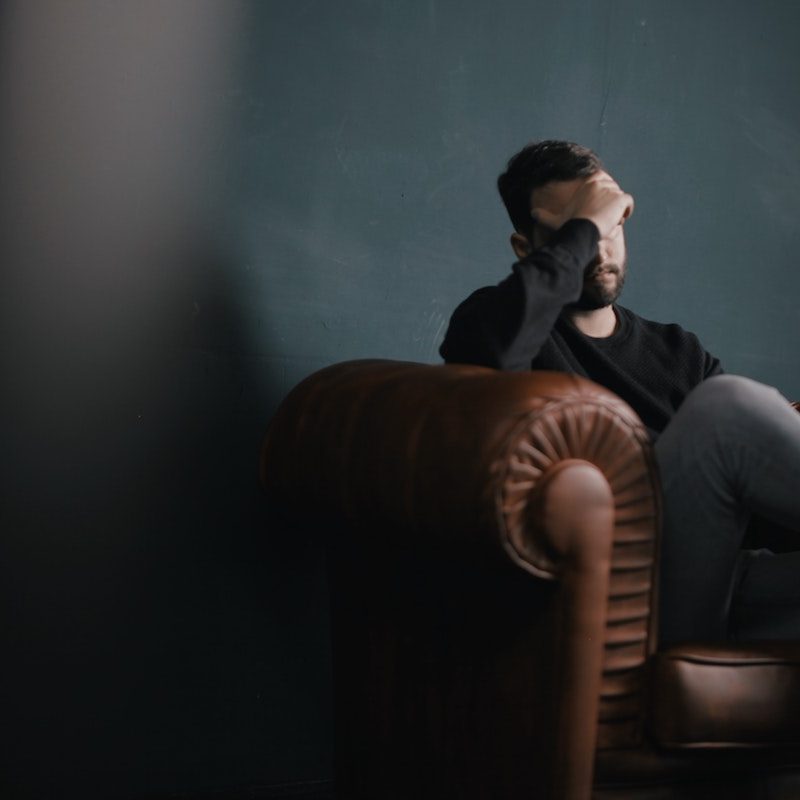 Man rubbing his temples with a migraine.