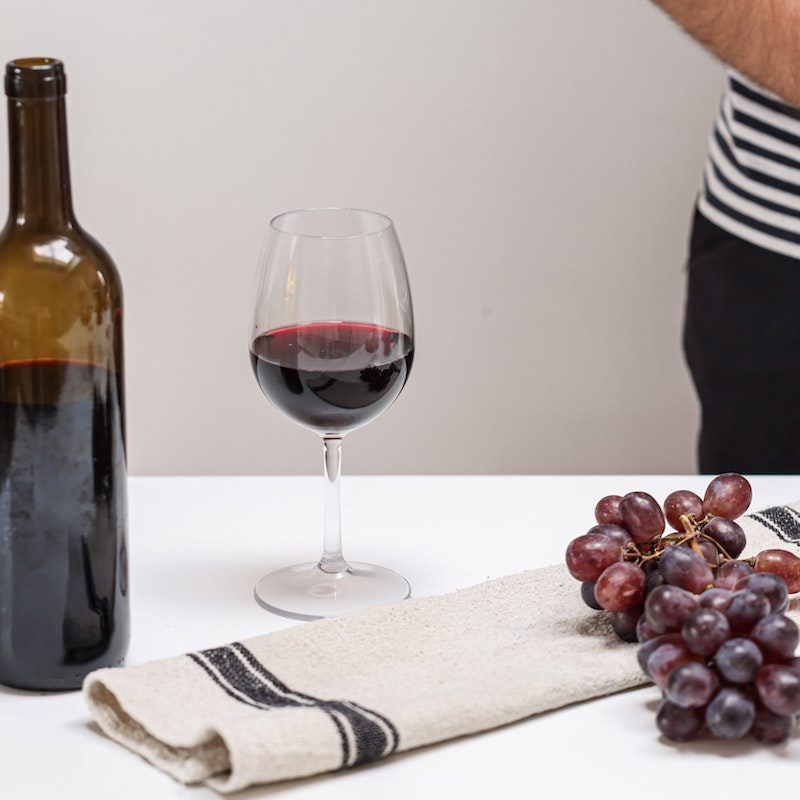 Wine and glass and grapes on a table.