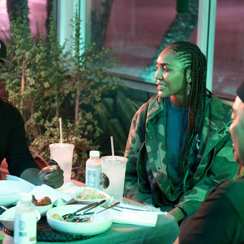 Roy Choi sitting at a table with artist/activist Chuck D and Mia Keeling of Simply Wholesome.