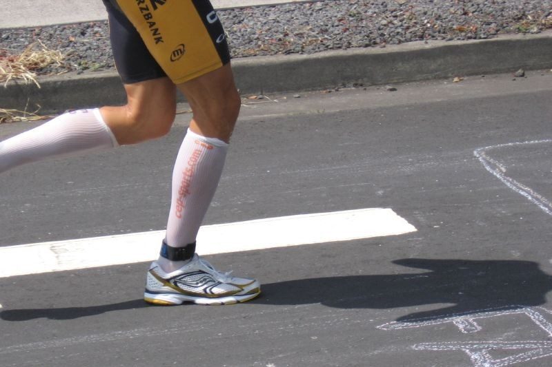 Lower portion of a man wearing running shorts and compression socks.