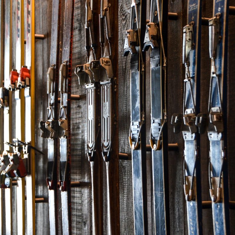 Skis hanging on wall with bindings.