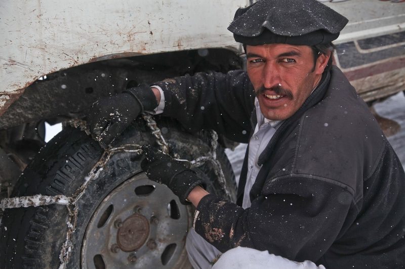 Man putting on snow chains