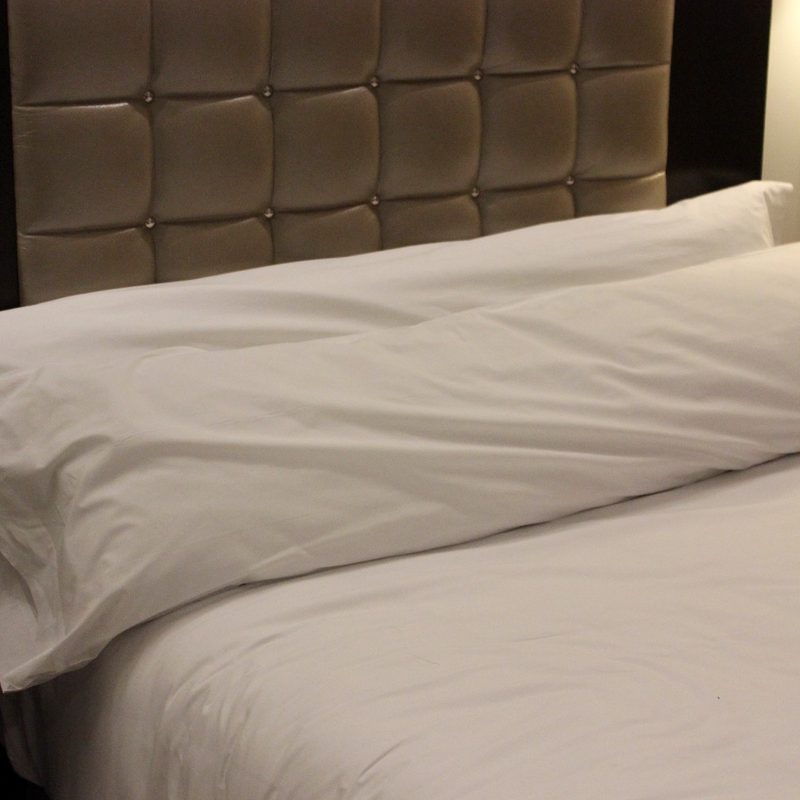 Long body pillows on a bed.