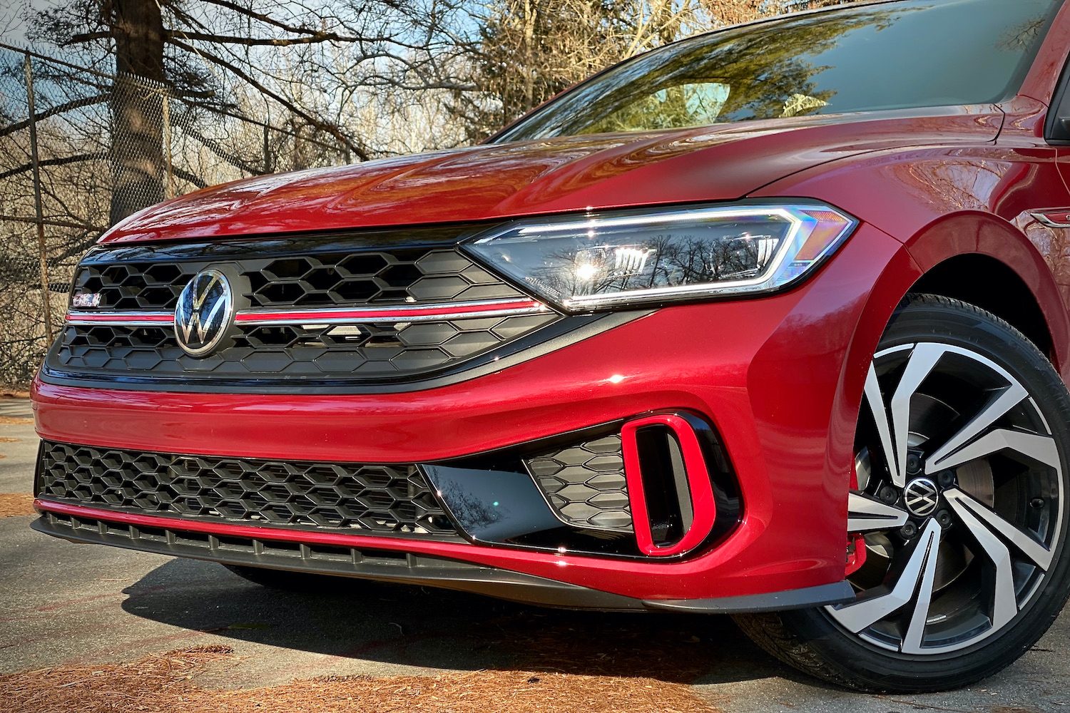 Close up of 2022 Volkswagen Jetta front end with trees in the background.