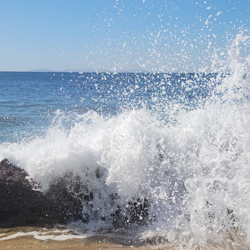 A wave splashes onto shore at Crystal Cove State Park in Laguna Beach, California.