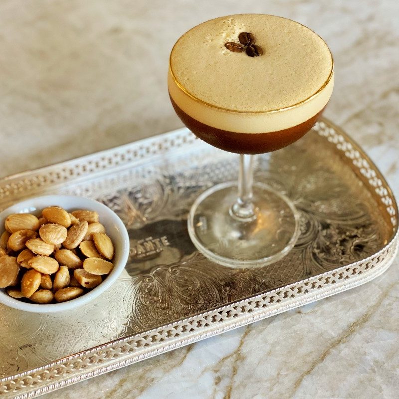 Amaro Averna Sicilian espresso martini on a serving tray next to toasted almonds.