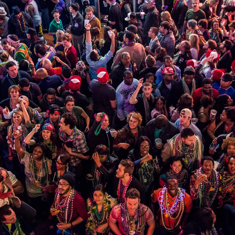 A bird's eye view of a crowd attending the Mardi Gras on the street.