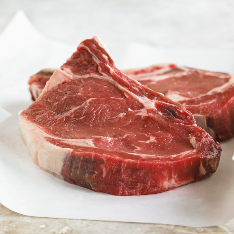 Two slices of raw beef on white paper