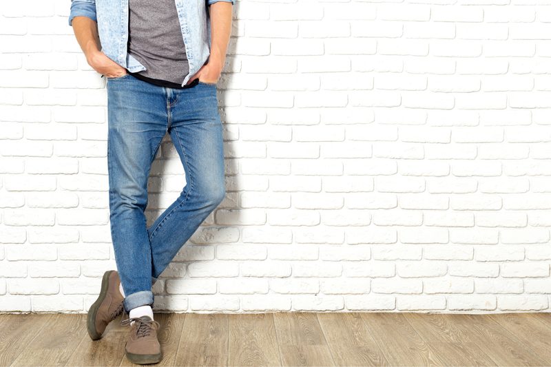 Man leaning against the wall in his favorite jeans