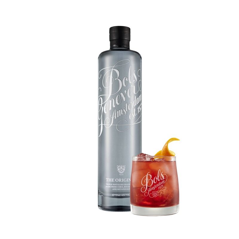 A bottle and a glass of Bols Genever with garnish on plain background.