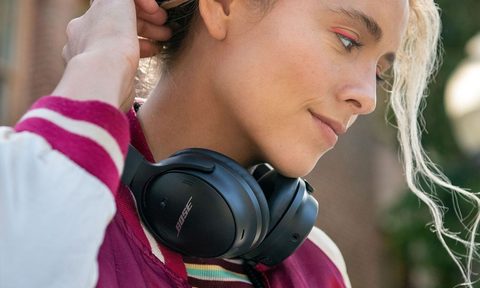 Woman wearing Bose QuietComfort 45 headphones around her neck.