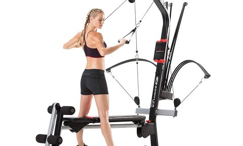 A woman working out using the Bowflex PR1000 Home Gym.