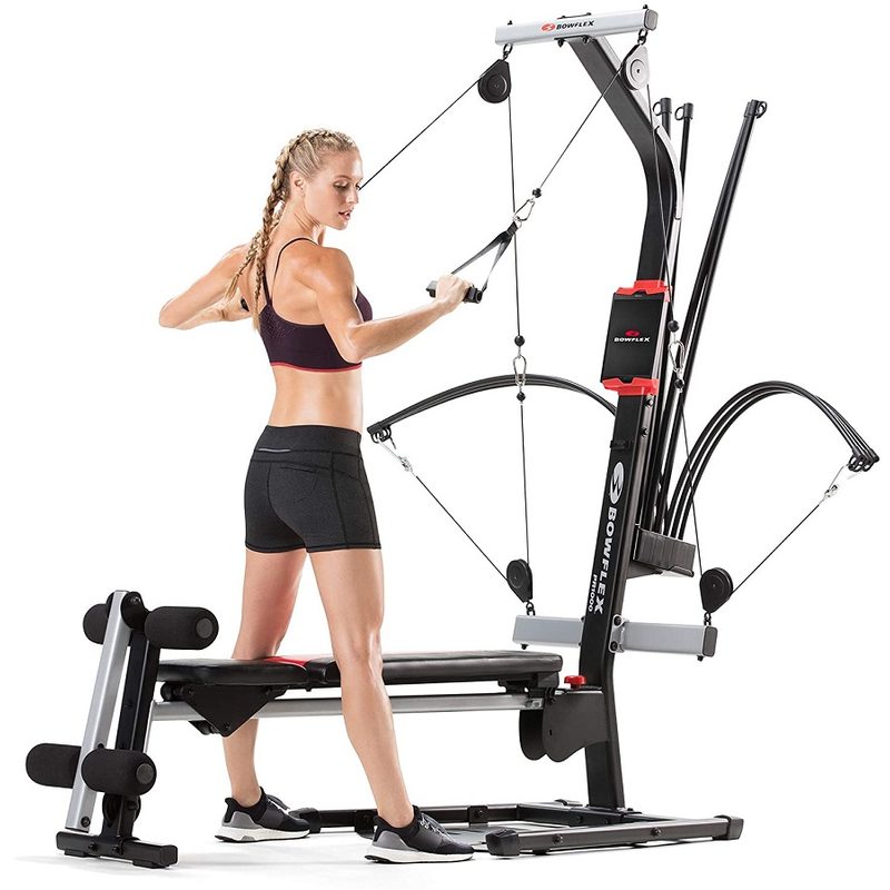 A woman working out using the Bowflex PR1000 Home Gym.