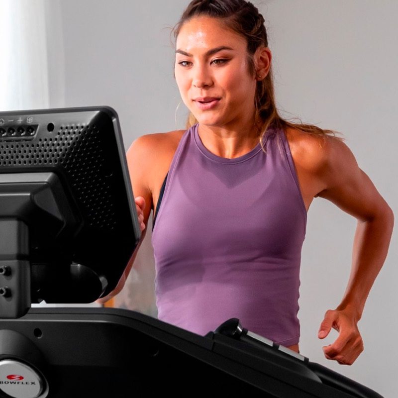 A woman runs on a Bowflex Treadmill 10.