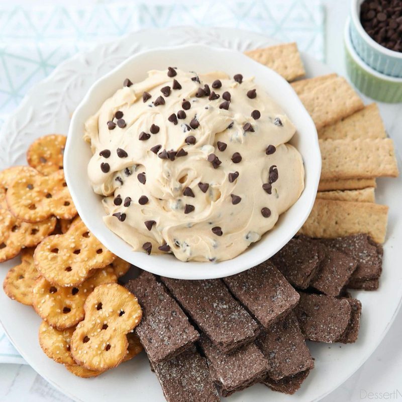 Buckeye dip with chocolate chips in a white bowl surrounded by crackers.