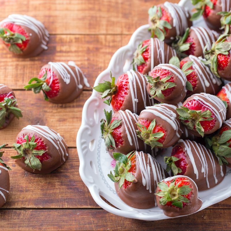 Chocolate-covered strawberries on a white plate.