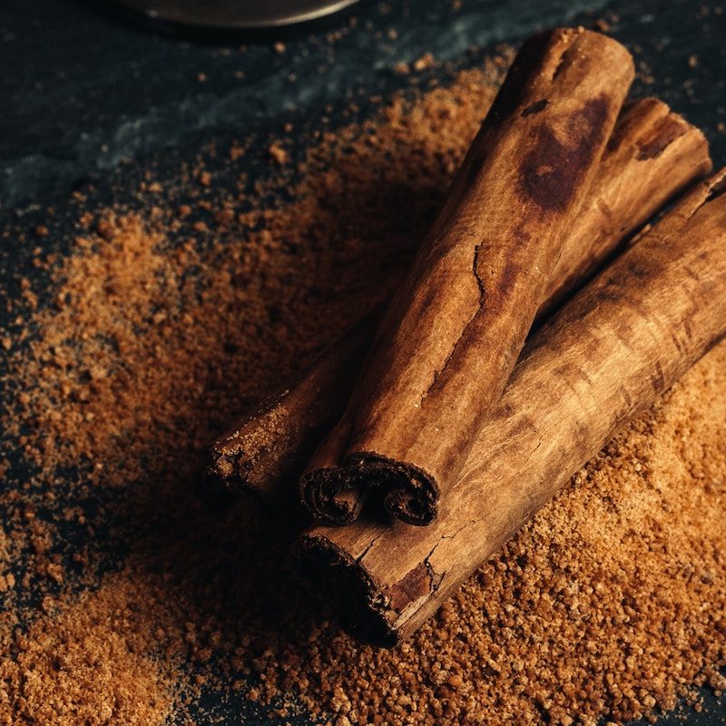 Thick cinnamon sticks on top of ground cinnamon.