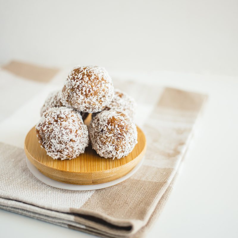Date balls on a bowl on a kitchen towel.