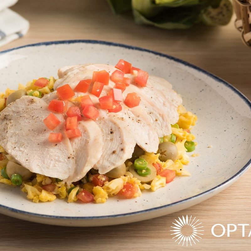 Arroz con pollo served on a plate on a table with "Optavia" at the bottom right corner.