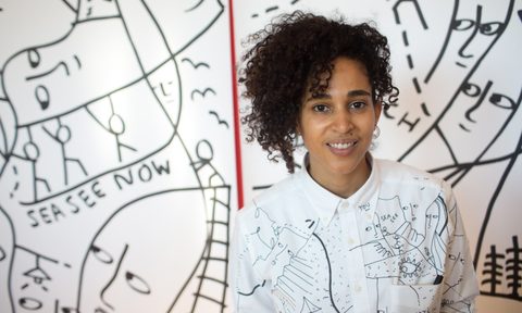 Shantell Martin posing with her art in the background.