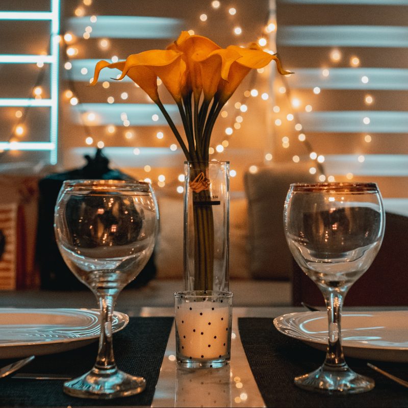 plates, wine glasses, and floral centerpiece on a table.
