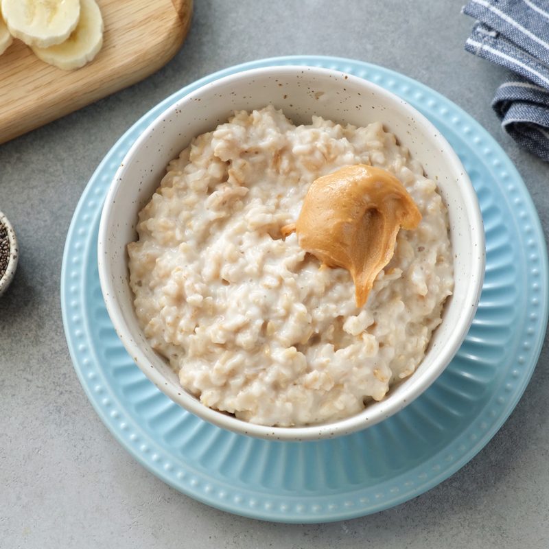 A bowl of oatmeal topped with banana slices.