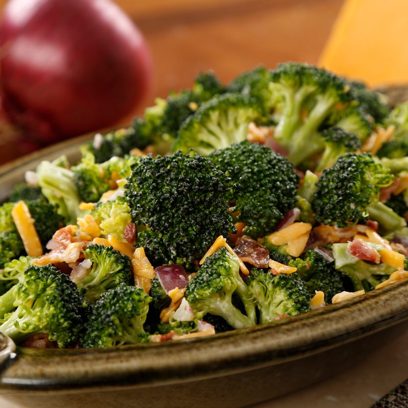 A close-up of broccoli salad served on an oval plate.