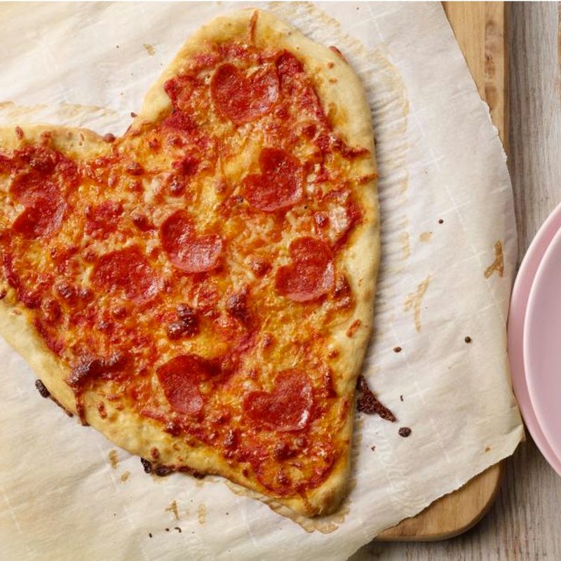 Heart-Shaped Pizza on parchment paper.