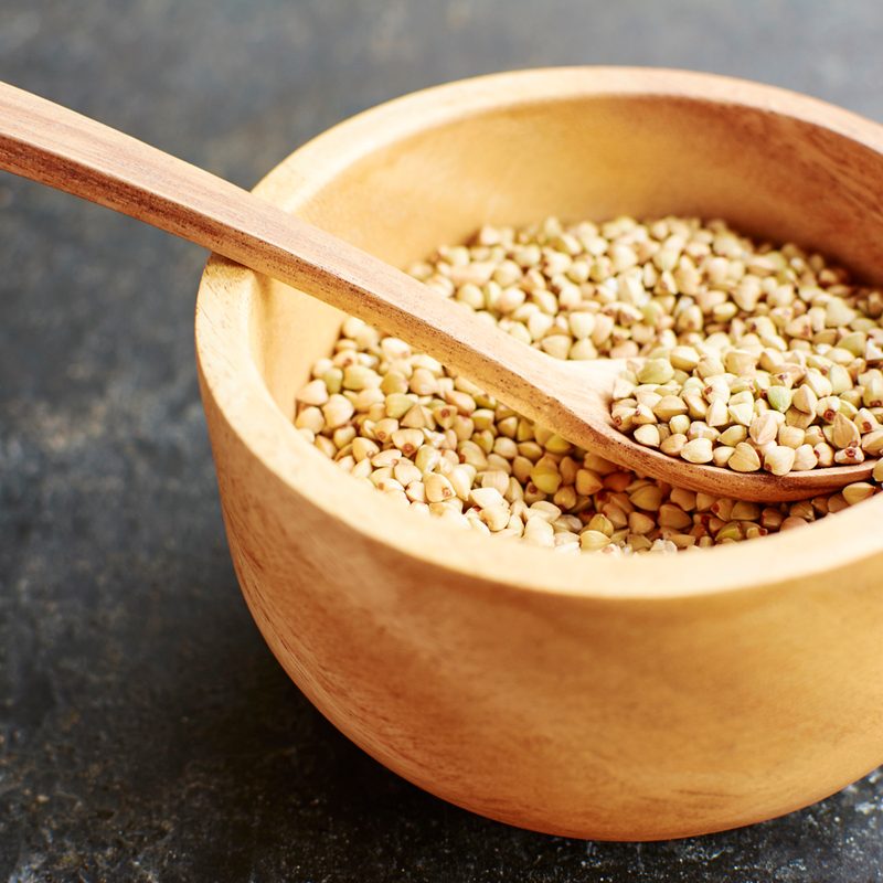 A wooden spoon in a bowl of hemp seeds.