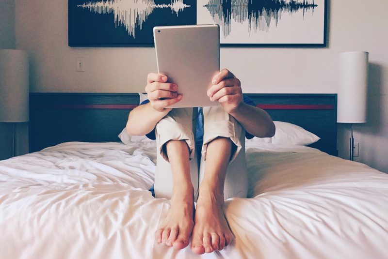 A Person Uses an iPad Tablet in Bed