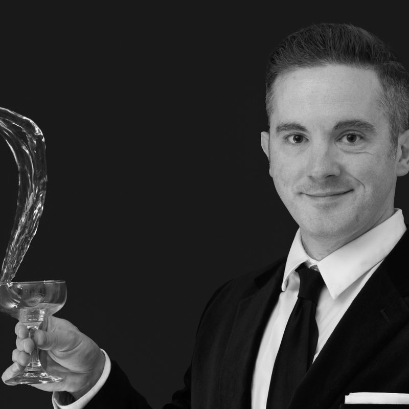 Jason Ericson in tux, holding a glass.