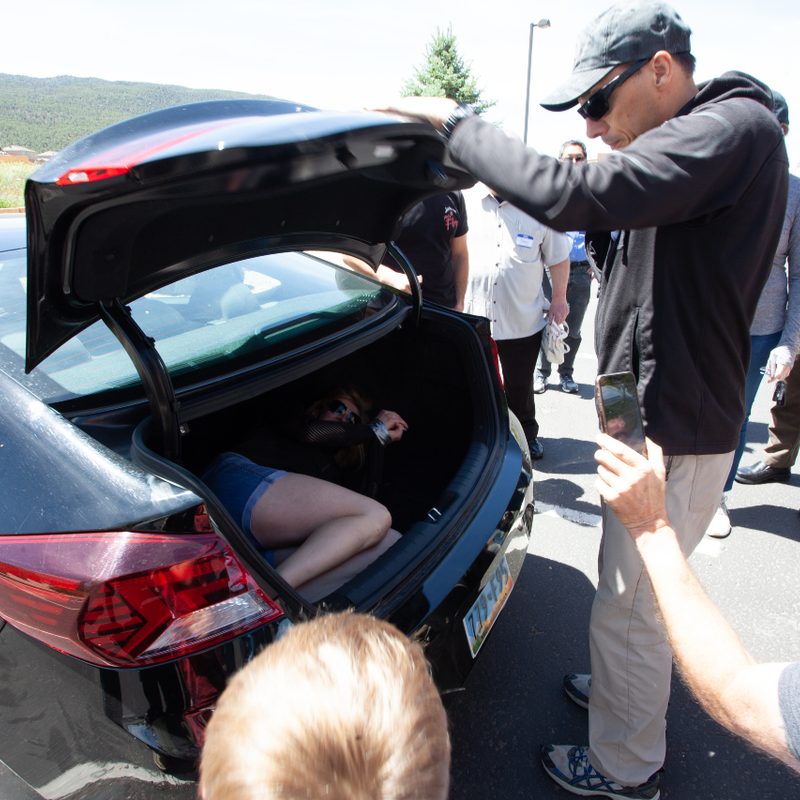 Jason Hanson demonstrating how to escape from a car trunk at Spy Week.