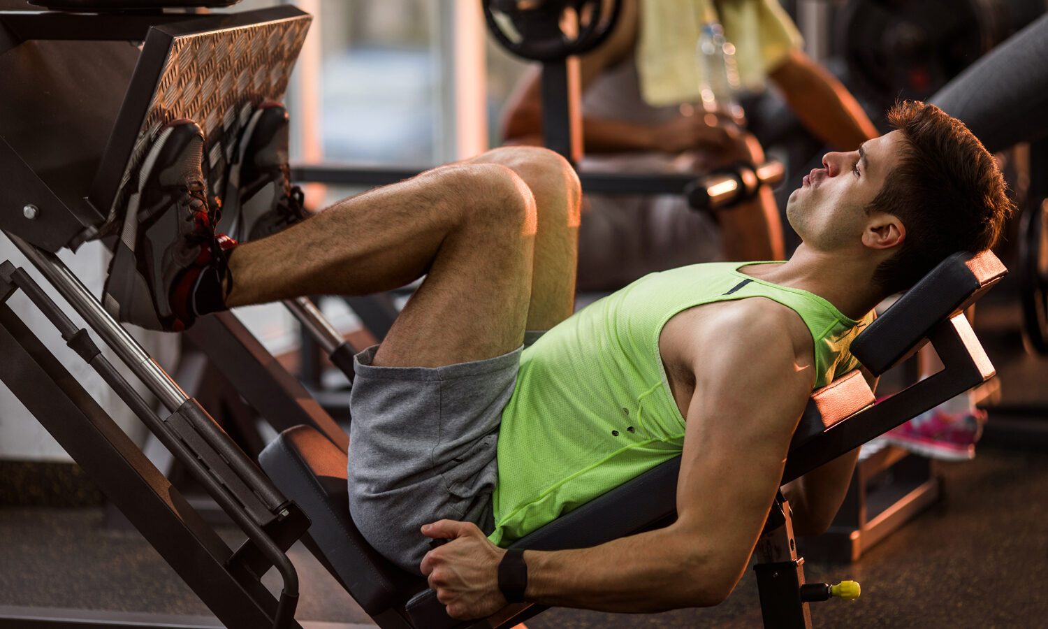 A man using a leg press in a gym.