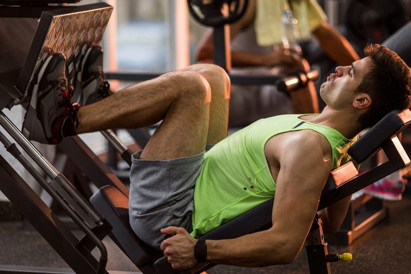 A man using a leg press in a gym.