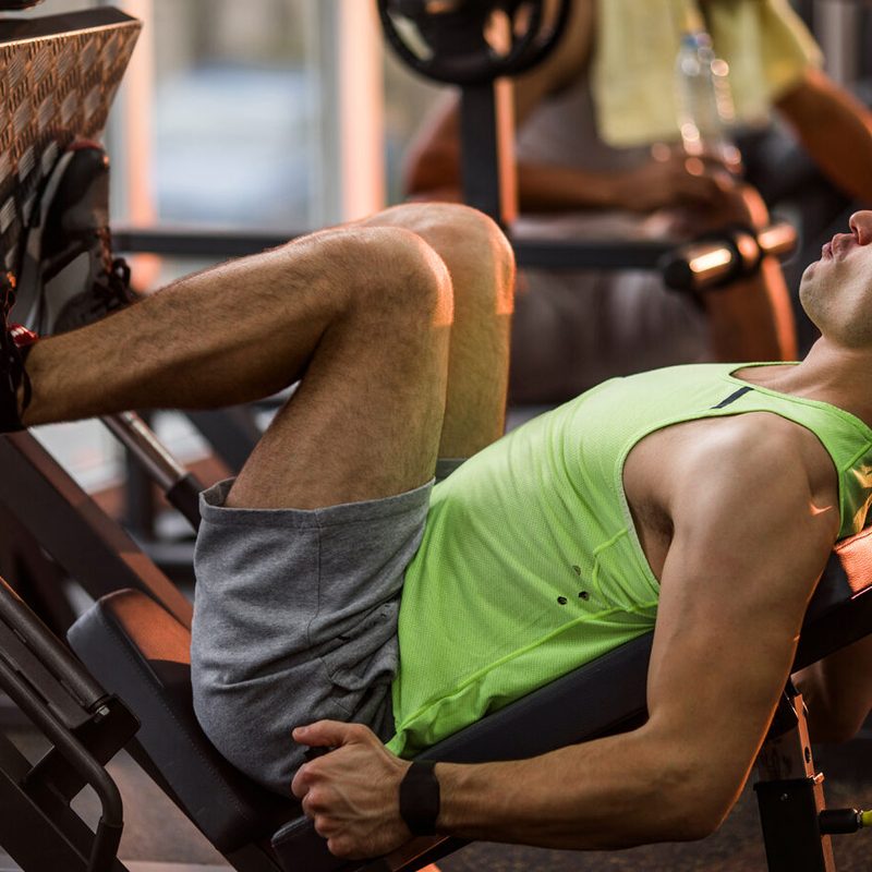 A man using a leg press in a gym.