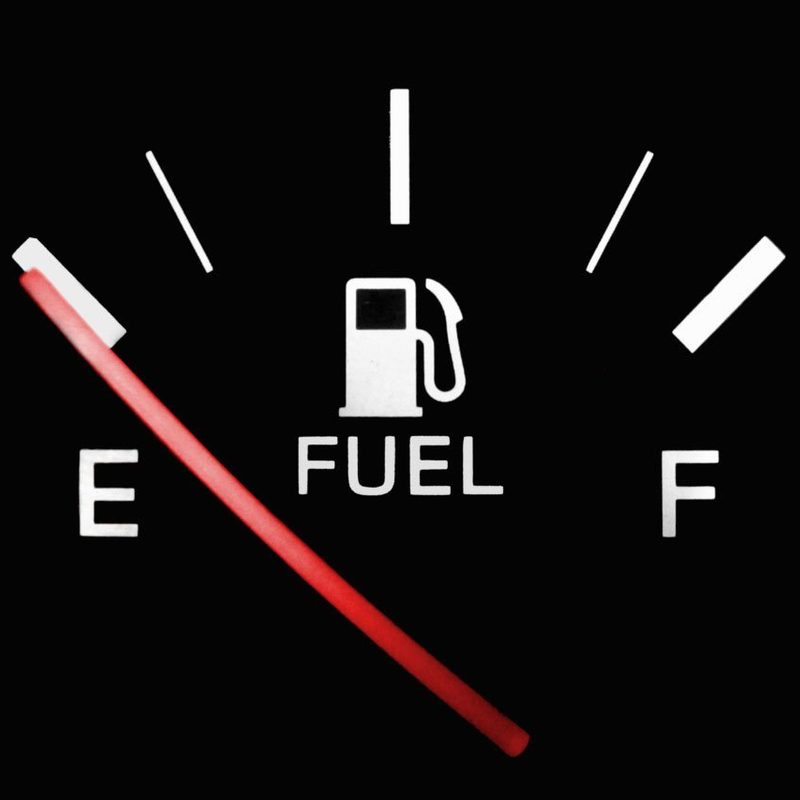 A low fuel car warning light on a dashboard.