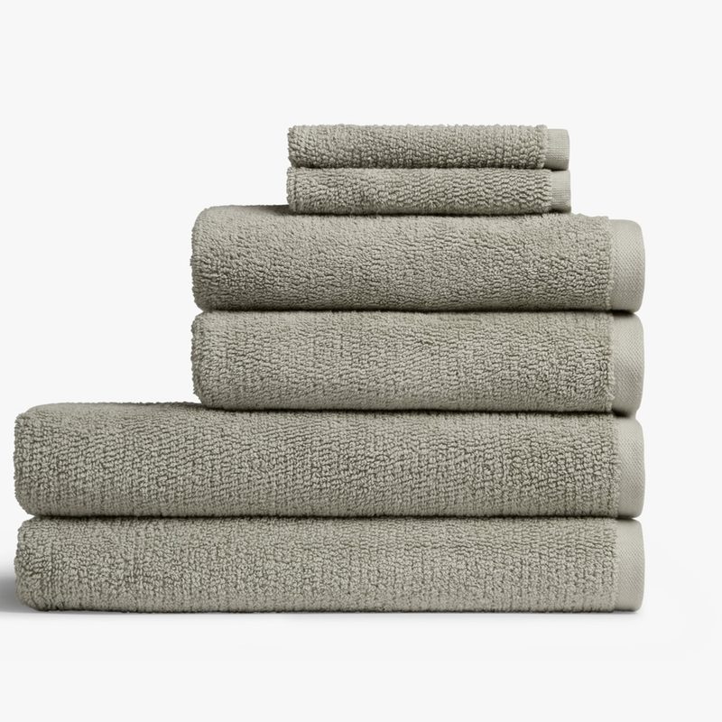 A stack of Parachute towels, from smallest to largest, on plain background.