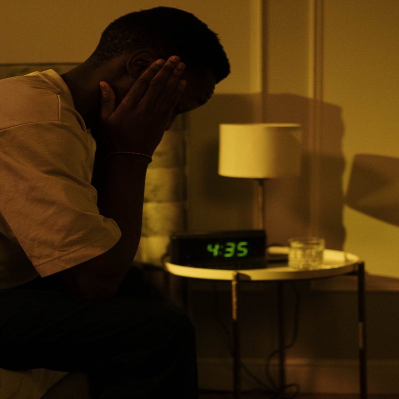 A man with insomnia struggles in bed.