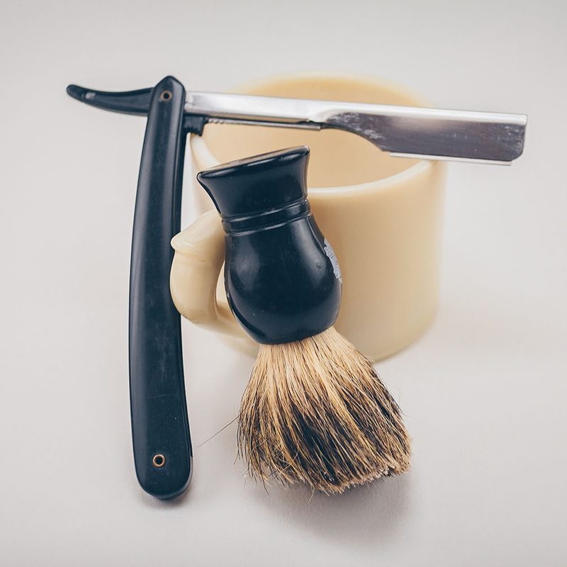 image of straight razor, shaving brush, and cup.
