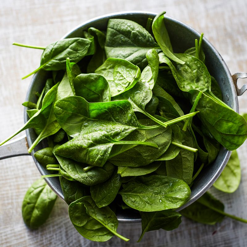 A close-up of spinach leaves on a colander