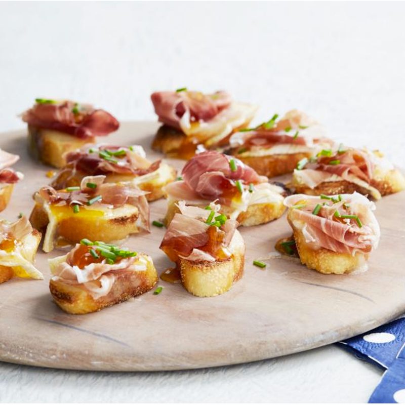 Prosciutto Crostini on a wood serving tray.