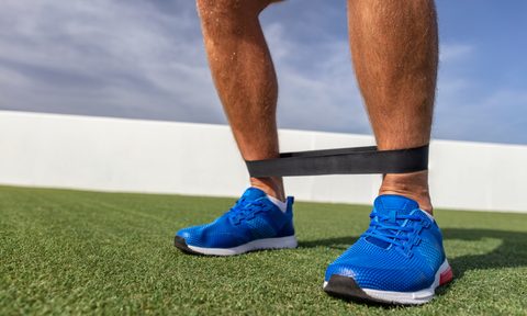 A resistance band around a man's ankles.